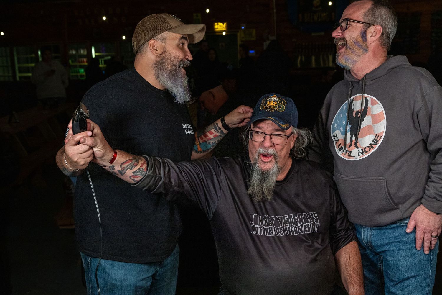 Veteran camaraderie in action at a community beard shave event – brotherhood, laughter, and support.