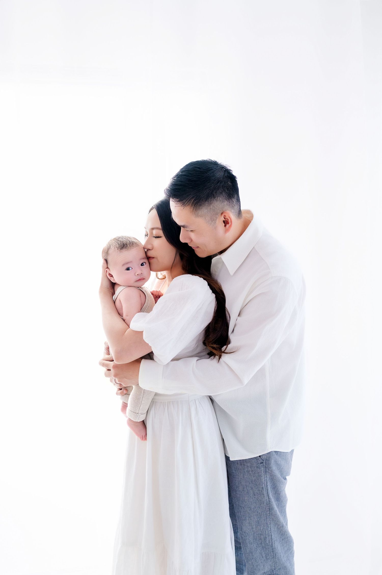 A tender family moment captured against a bright white background.