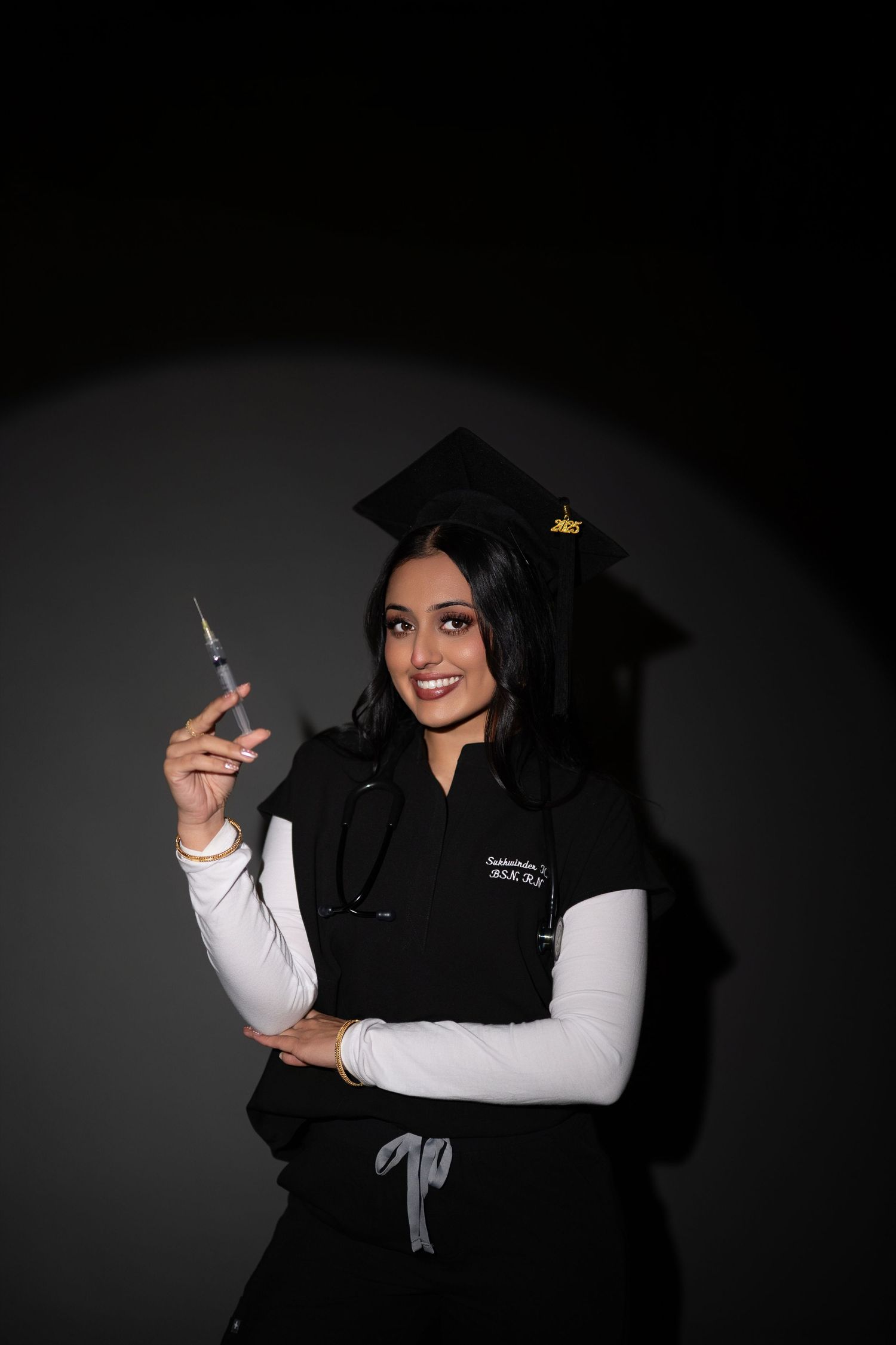 A figure in a black graduation gown and white sleeves poses against a dark background in a series of artistic portraits.