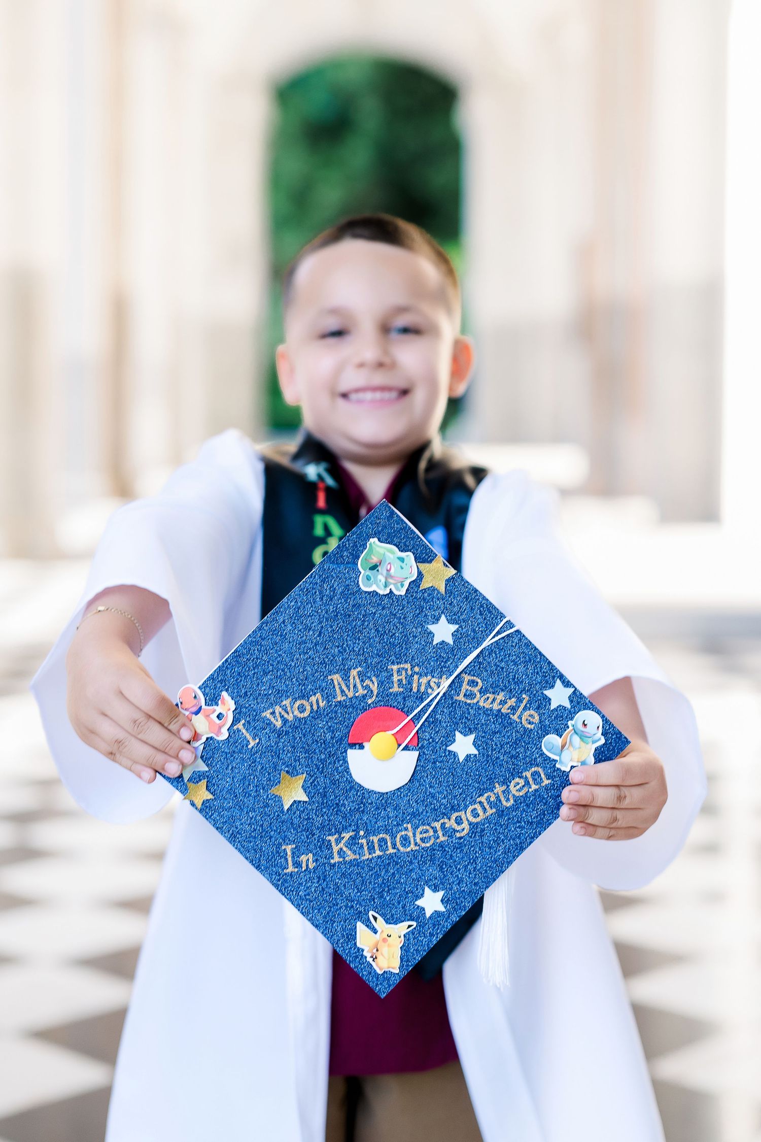 Decorated graduation cap with blue fabric and stars saying 'My First Day of Kindergarten'.