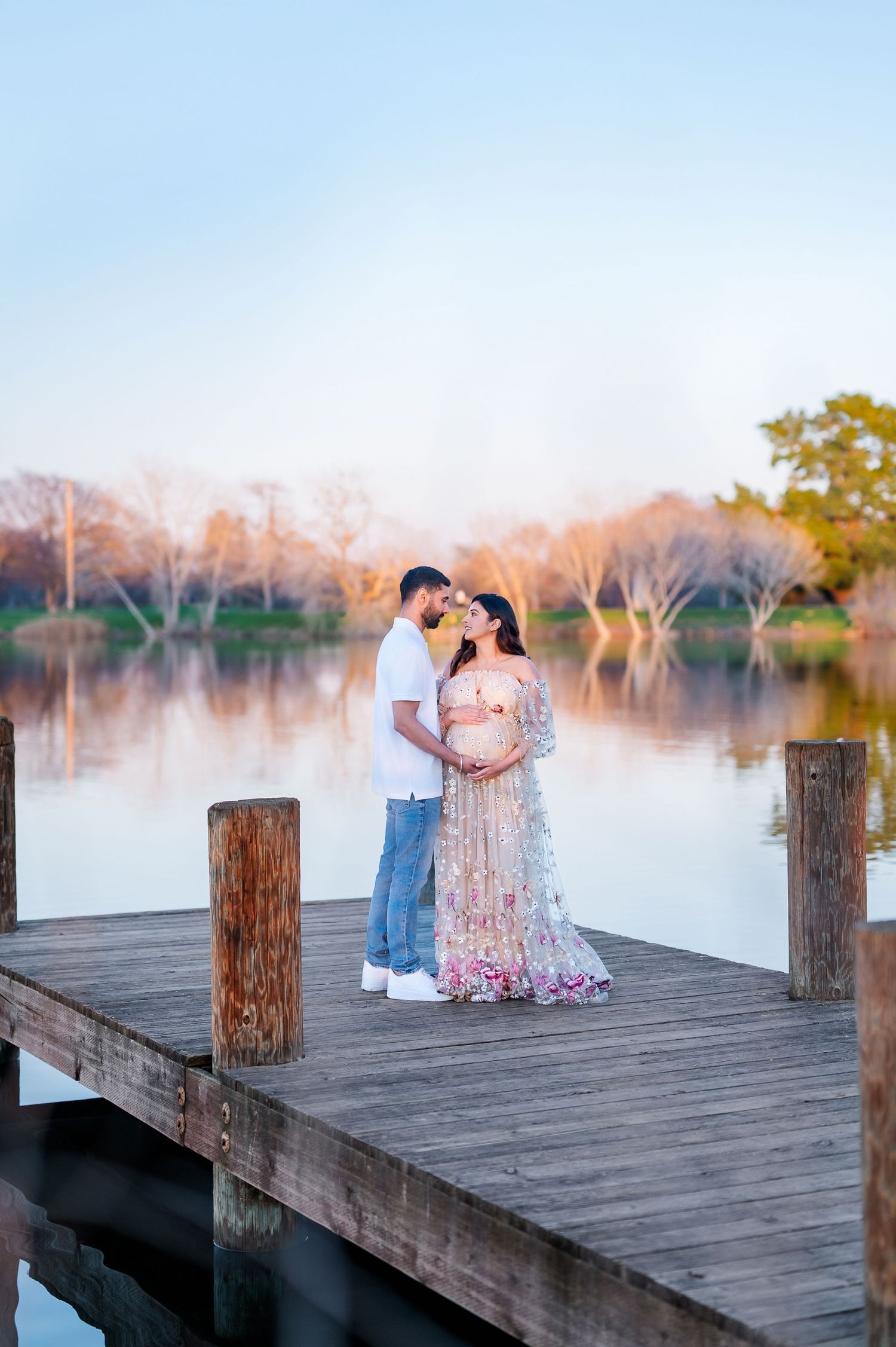 Romantic sunset photoshoot on a misty wooden dock by the lake.