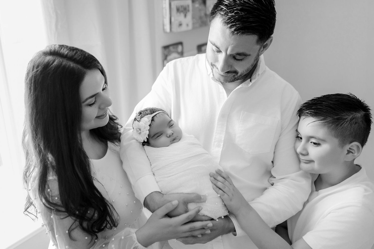 A tender black and white family moment captured during a newborn photo session.