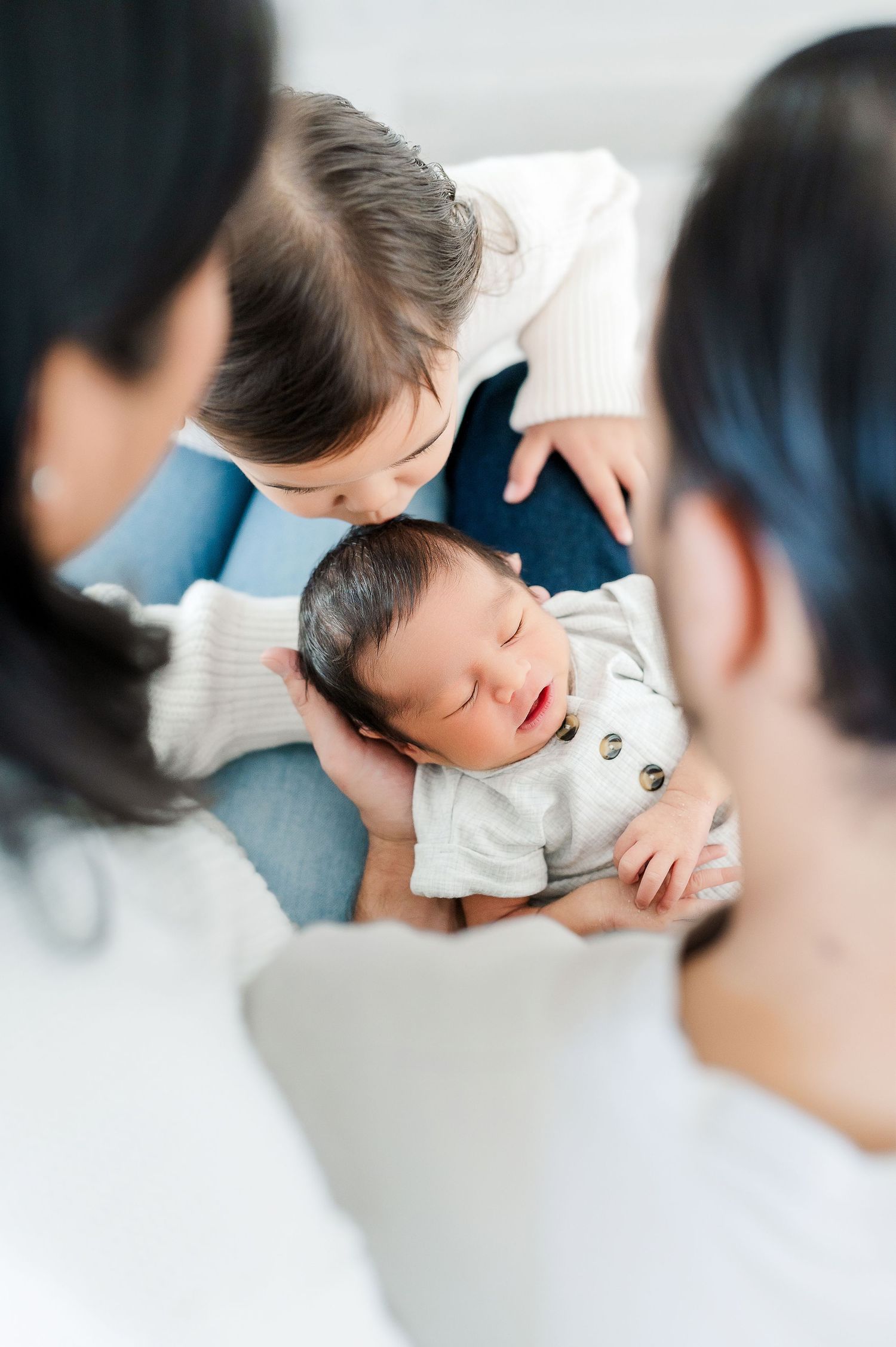 Parents and baby sharing intimate moment together during lifestyle photoshoot.