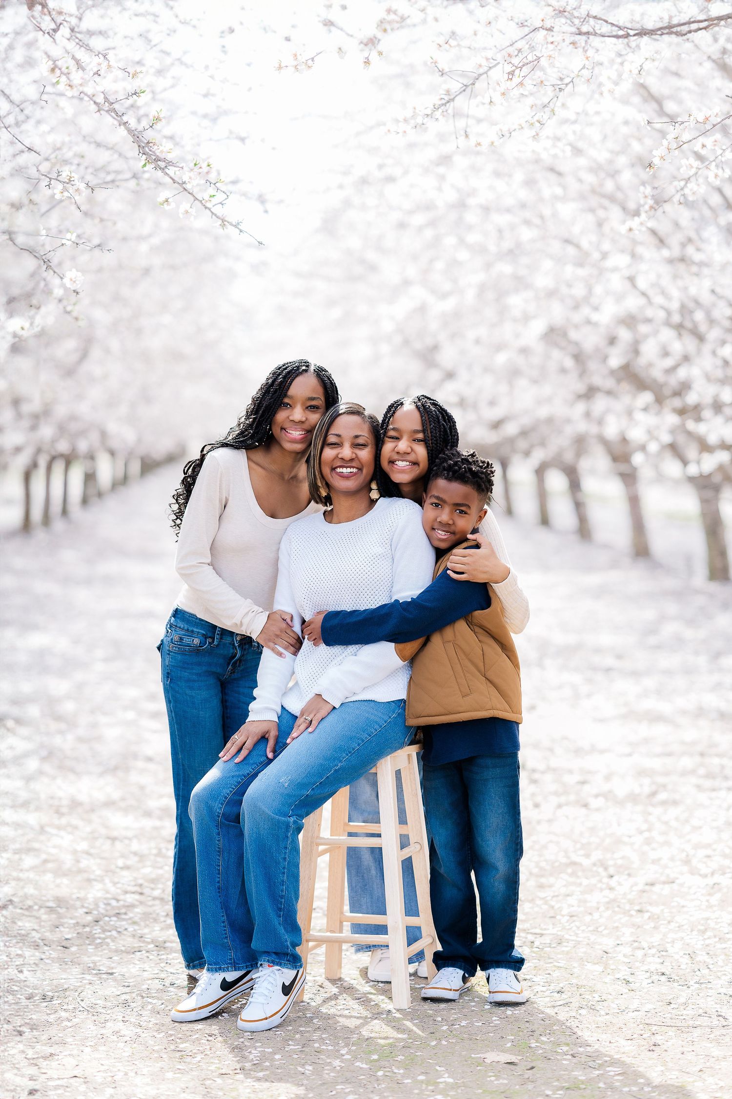 Joyful family portrait under blooming cherry blossom trees.