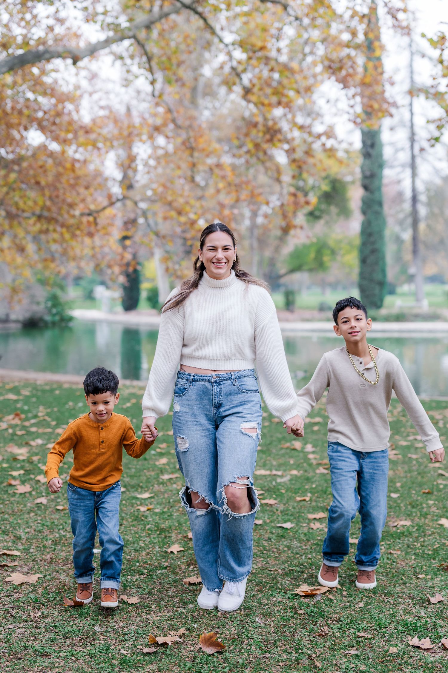 A playful sequence of jumping and running movements captured in autumn leaves on a grassy lawn.