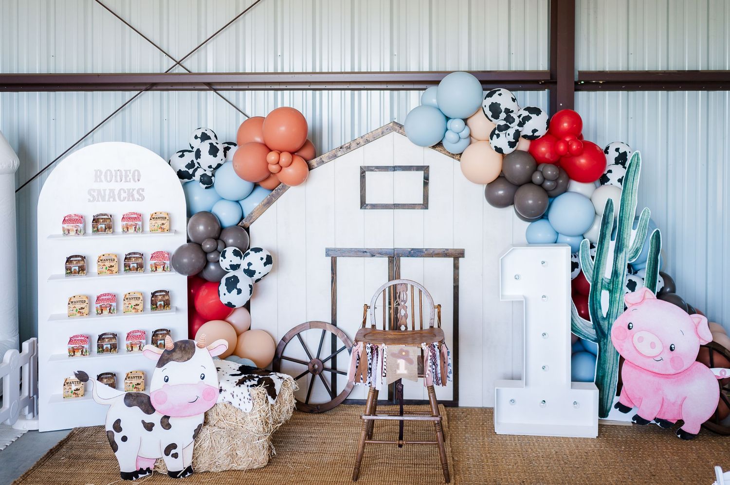 Decorated party space with blue and white balloons, stuffed animals, and panda-themed decor for a special celebration.