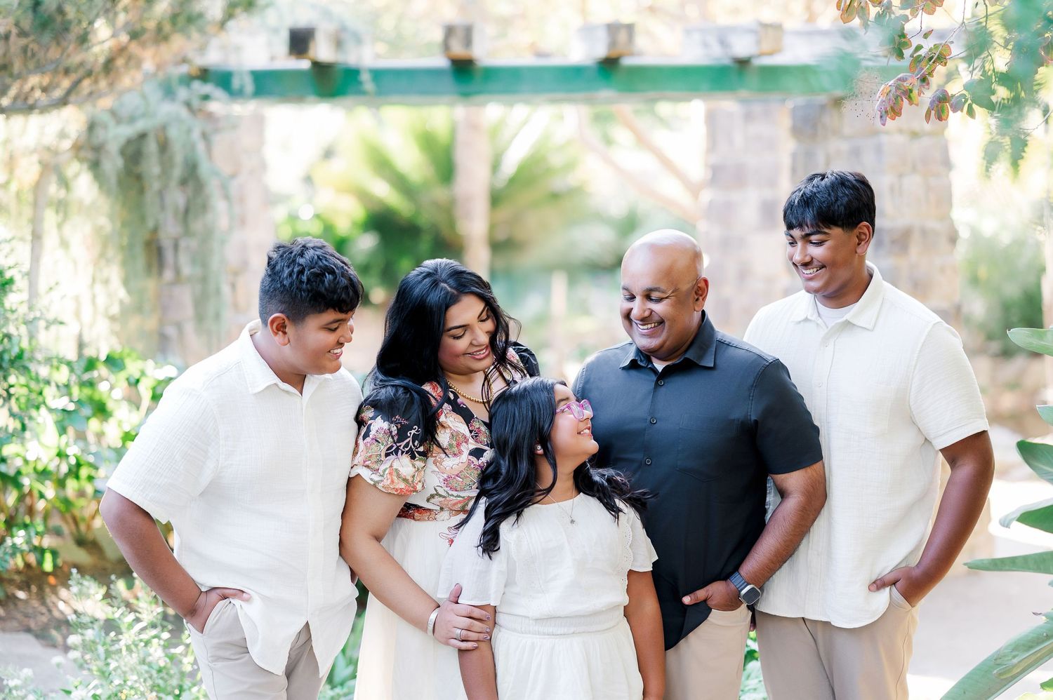 A series of outdoor family photos showing joyful moments and embraces in a garden setting with natural greenery.