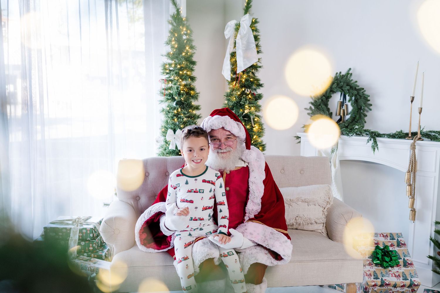 A festive Christmas scene with decorated trees, white lights, and a cozy sofa in a bright room.
