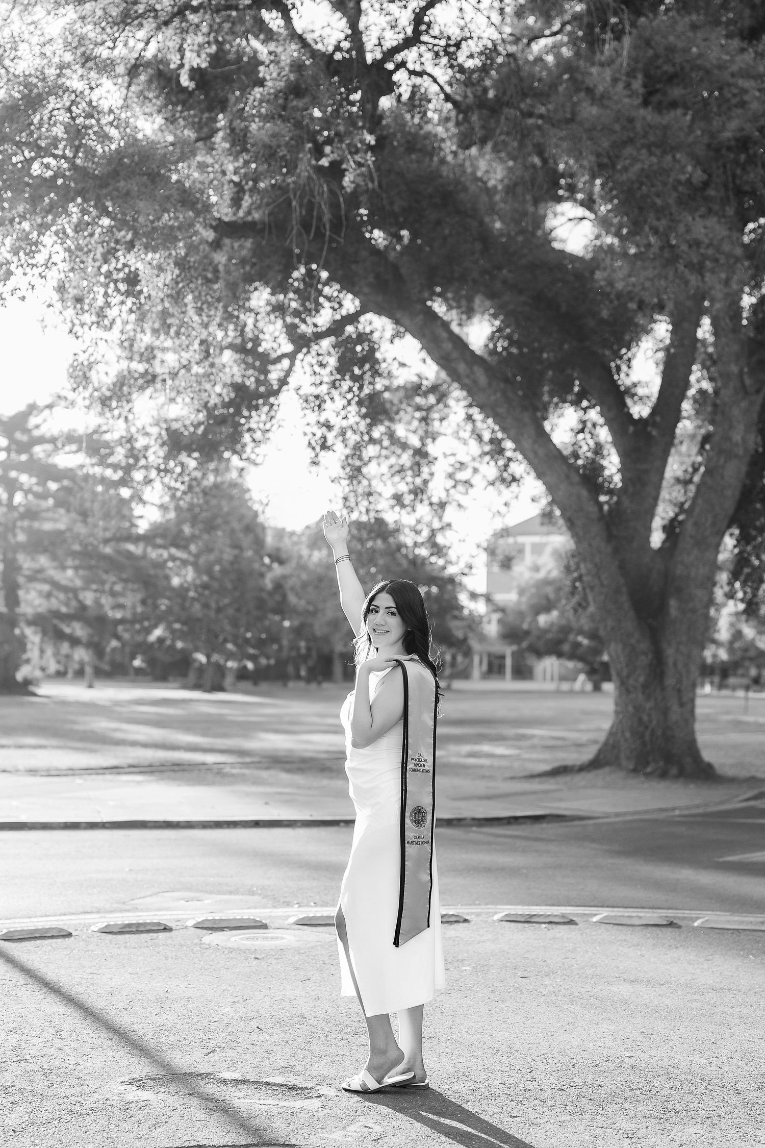 Black and white graduation portraits taken under majestic oak trees on campus grounds.