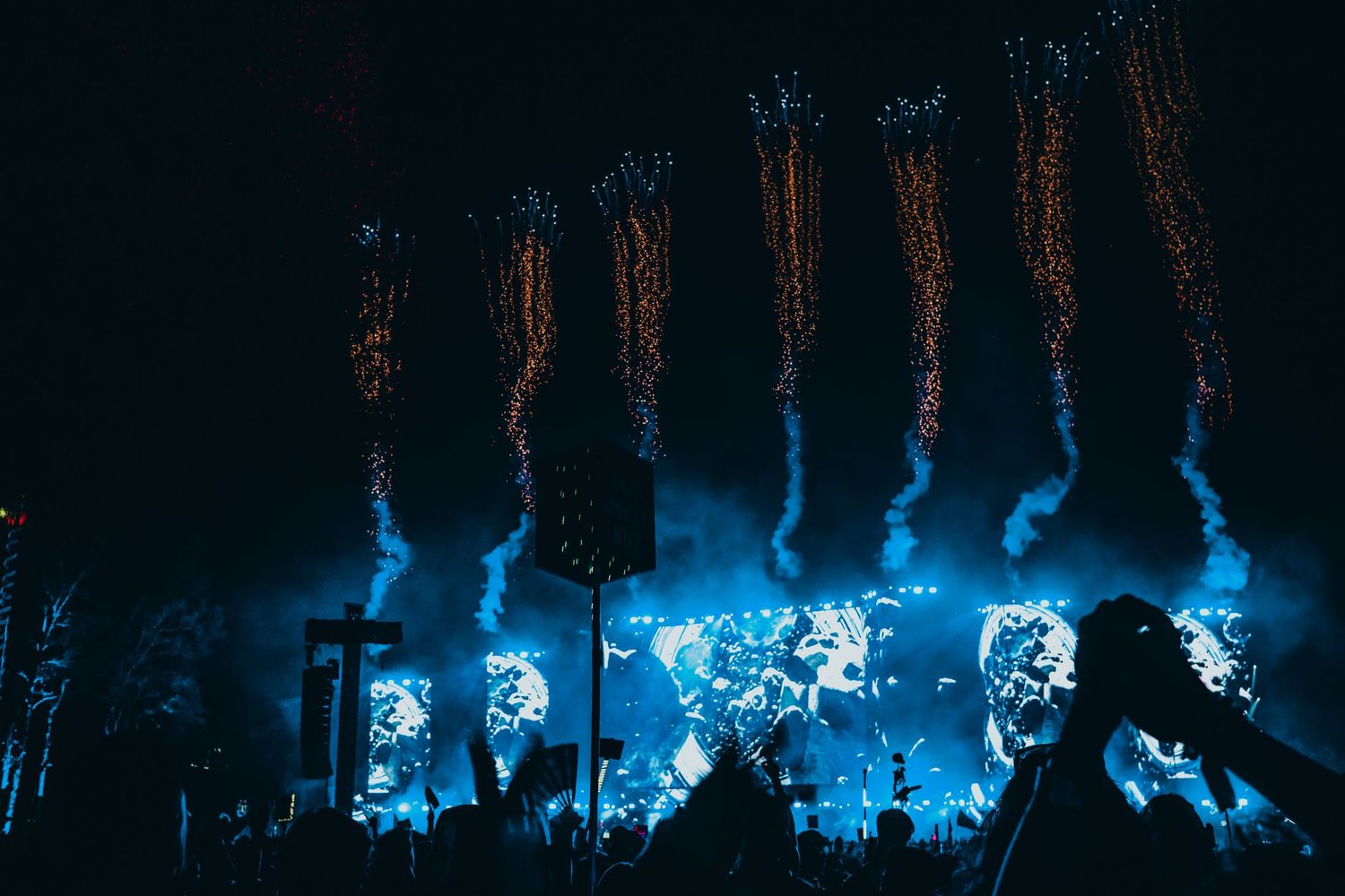 Concert stage illuminated with bright blue lights and fog effects creating an atmospheric performance environment.