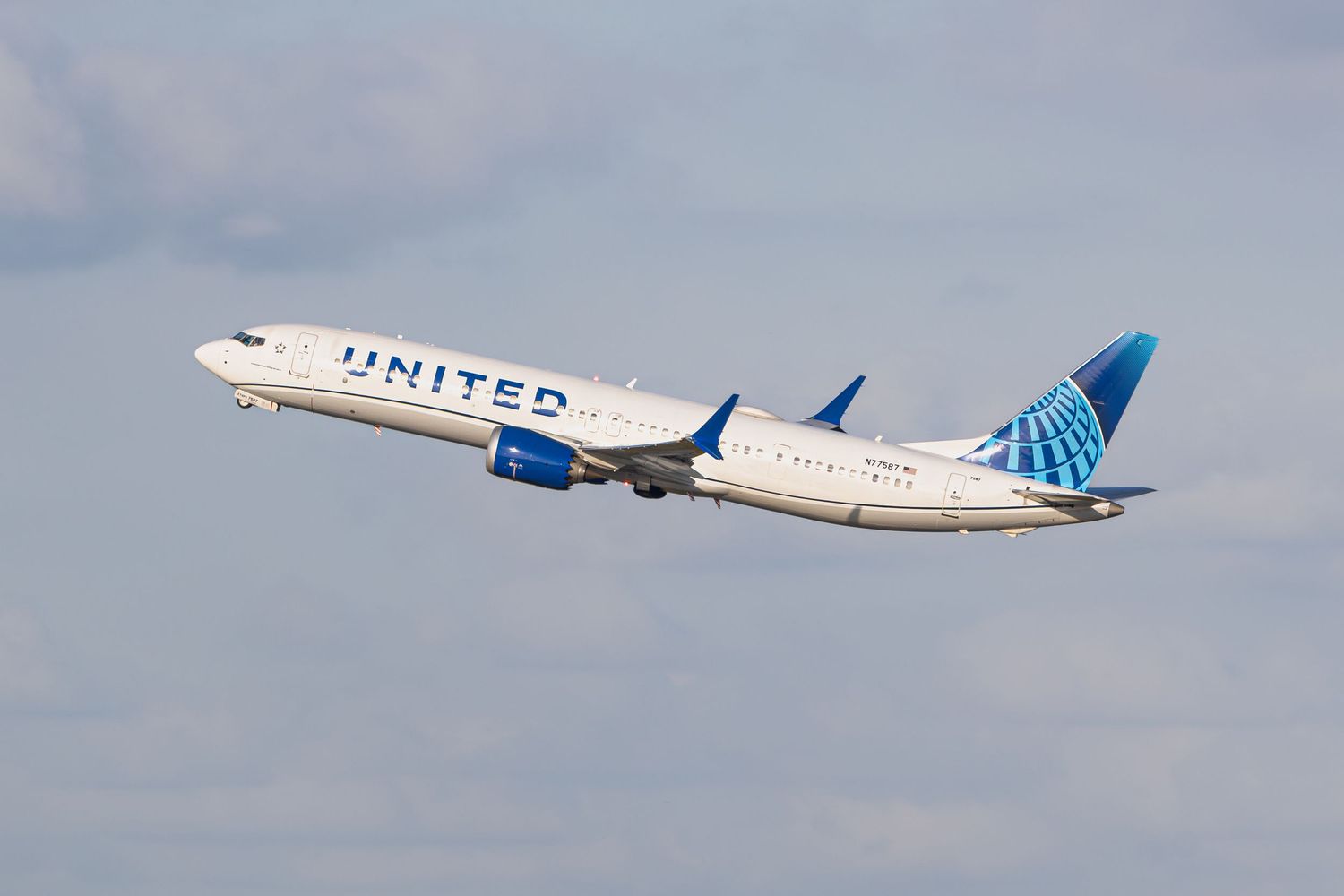 United Airlines Boeing 737 aircraft taking off against a cloudy sky, showcasing the airline's blue and white livery.