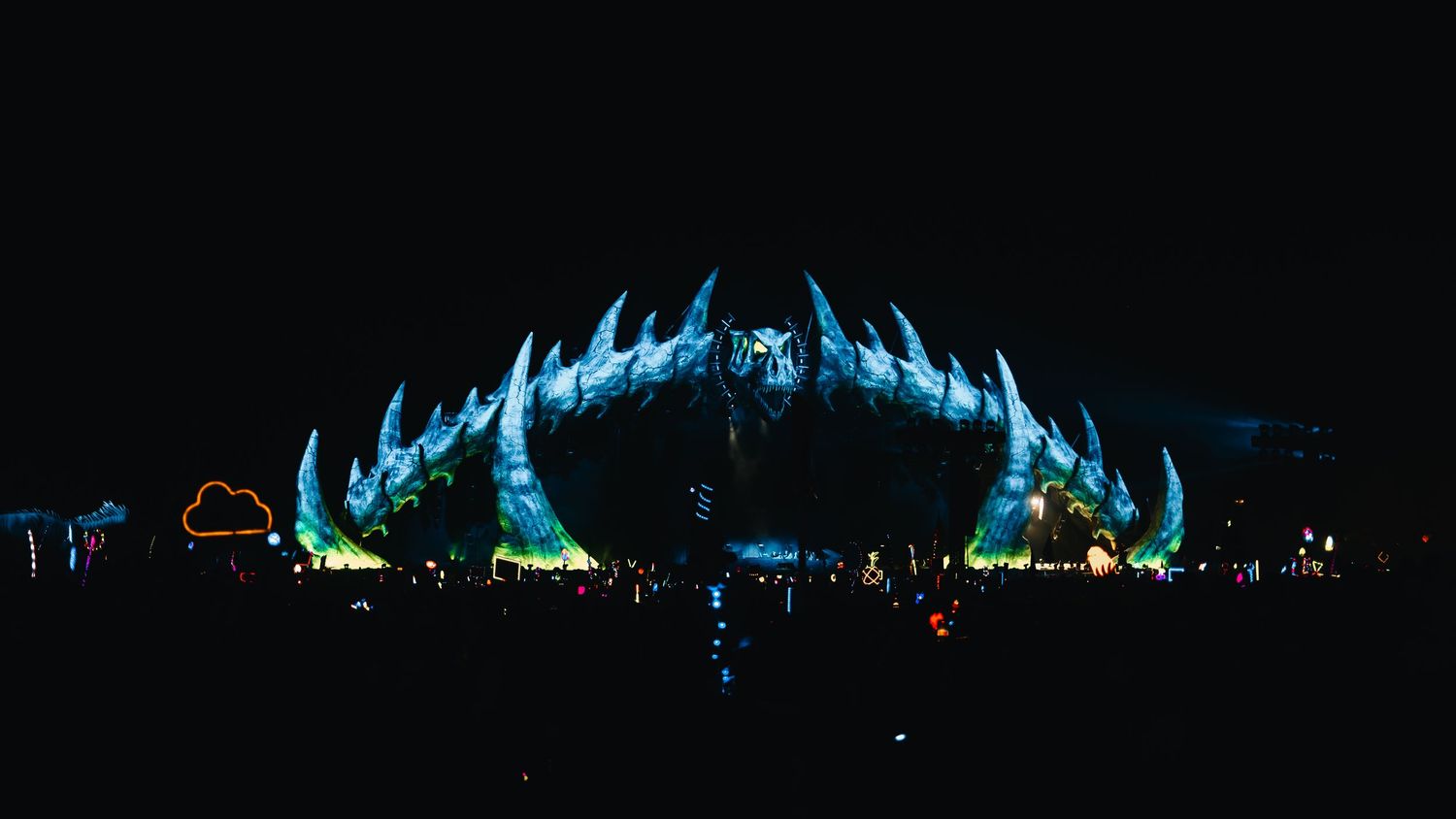 Panoramic view of a blue illuminated light show display against a dark night sky.