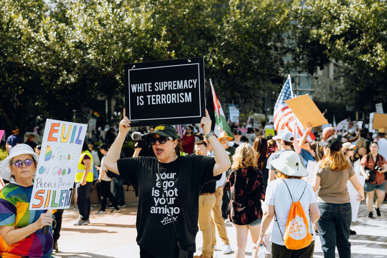 Protesters hold up colorful signs and banners during a large rally against white supremacy.