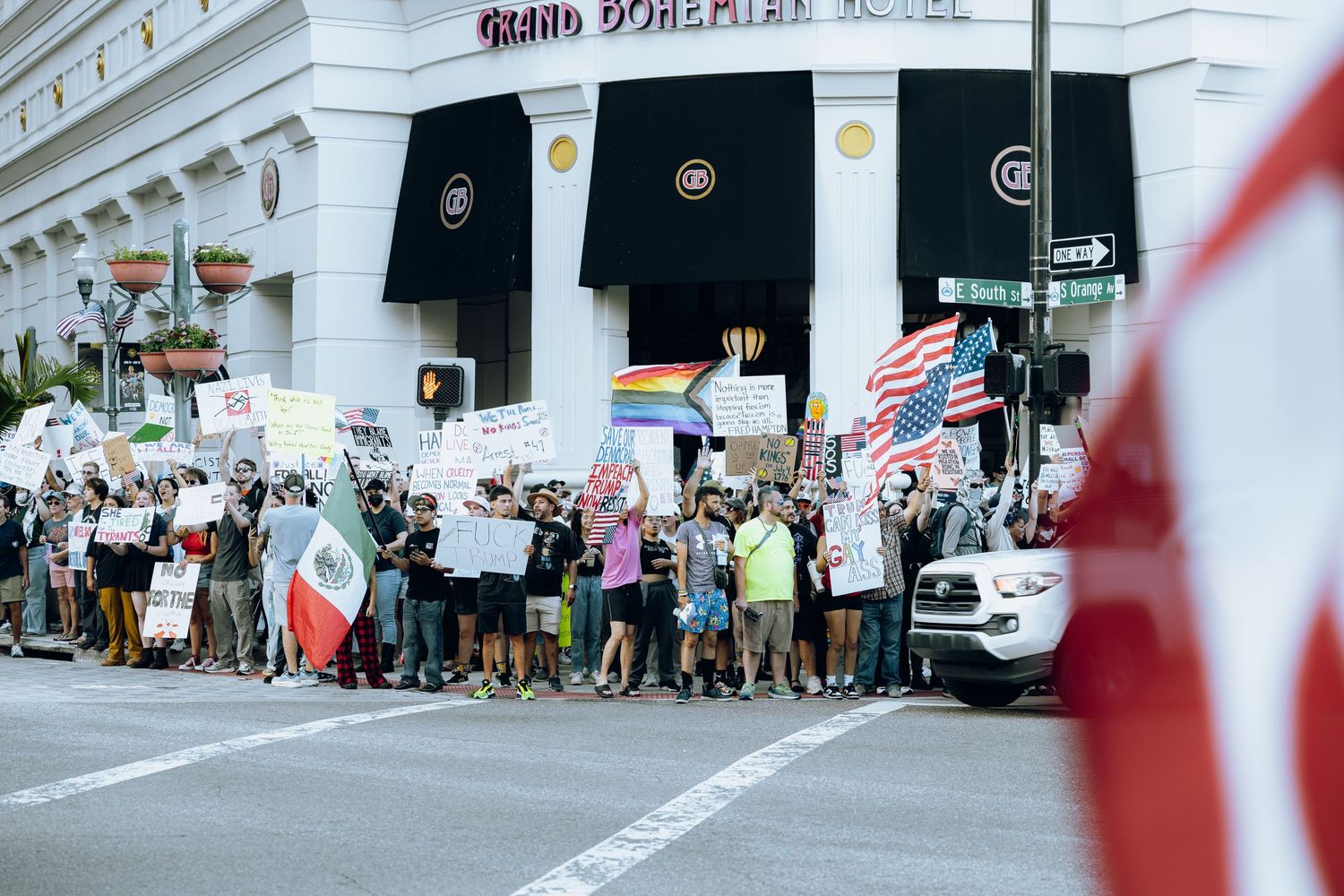 A crowd of protesters gathers outside a courthouse building with signs during a demonstration.