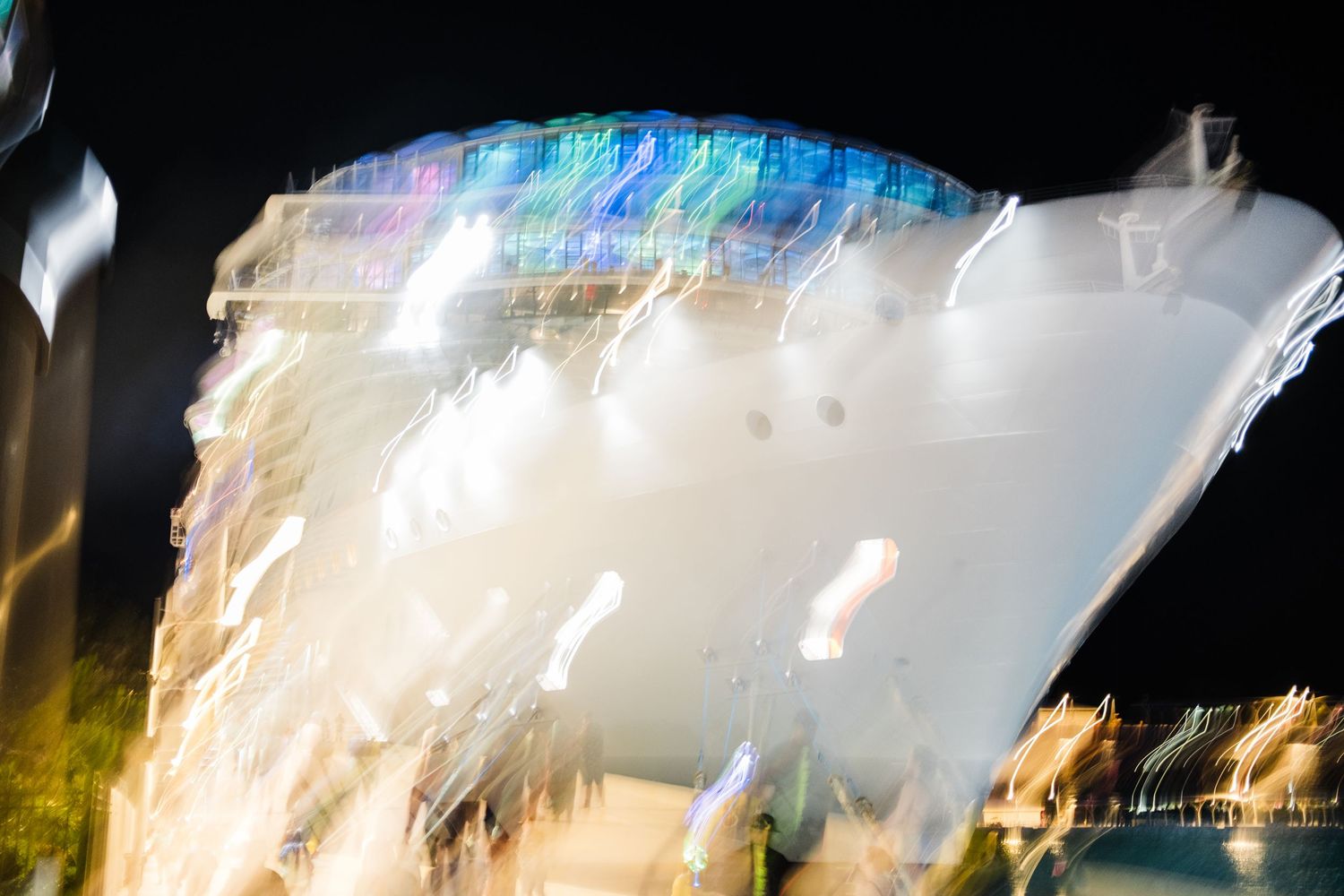 Long exposure photograph shows blurred white light trails against a dark background creating an abstract pattern.