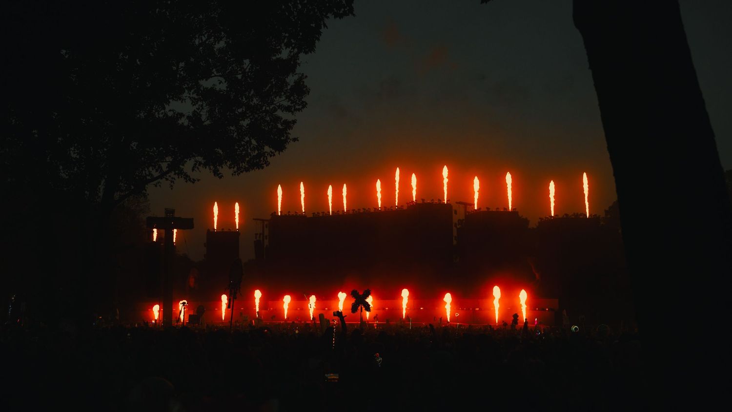 A row of glowing orange candles illuminates a dark space creating a warm and peaceful atmosphere.
