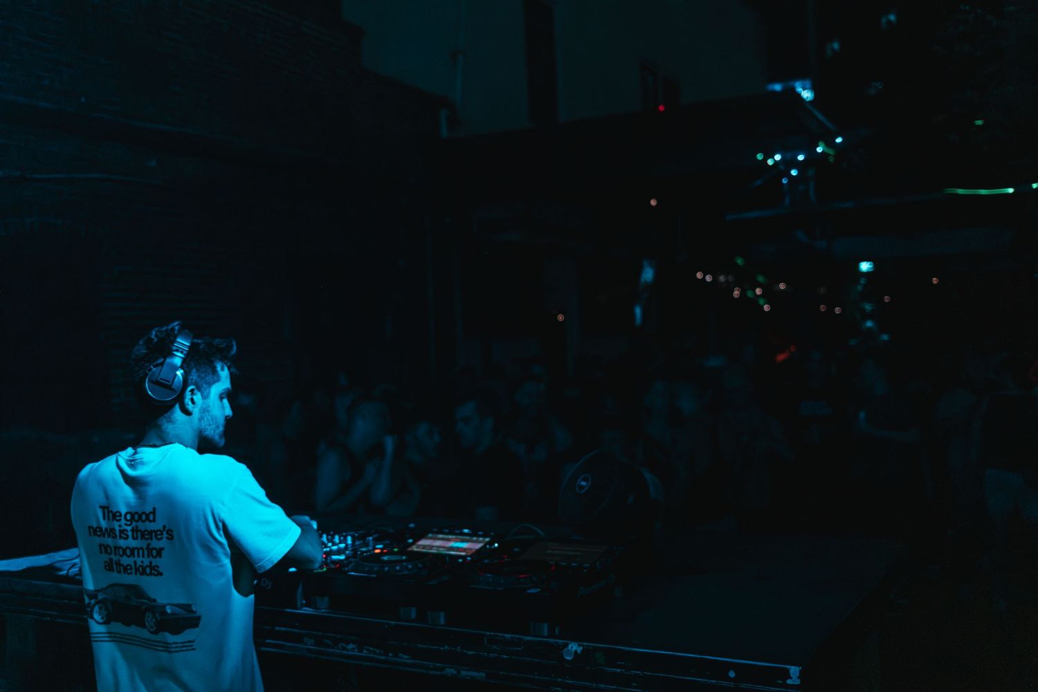 Concert performer on stage illuminated by blue lighting during a live music performance.