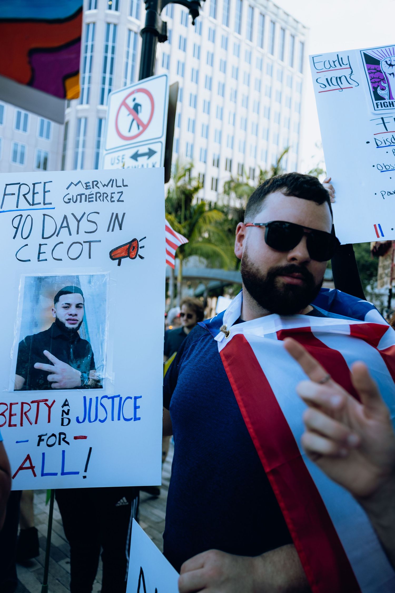 Protester with signs calling for justice holding a placard advocating for liberty at an urban demonstration.