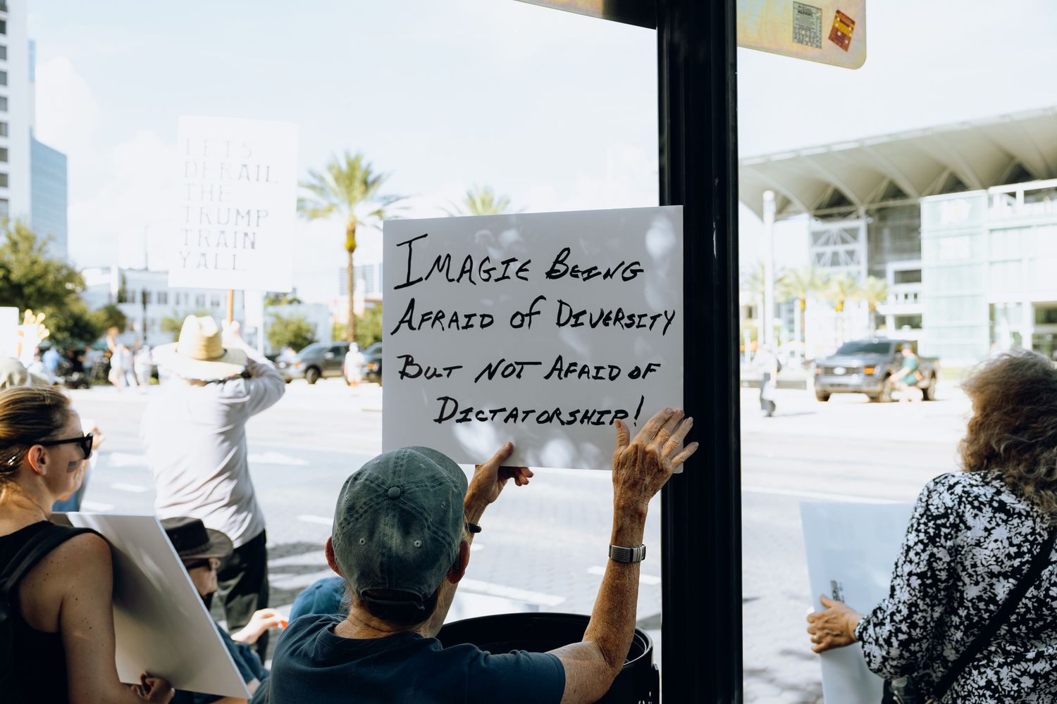Protest sign being held up inside building window during demonstration.