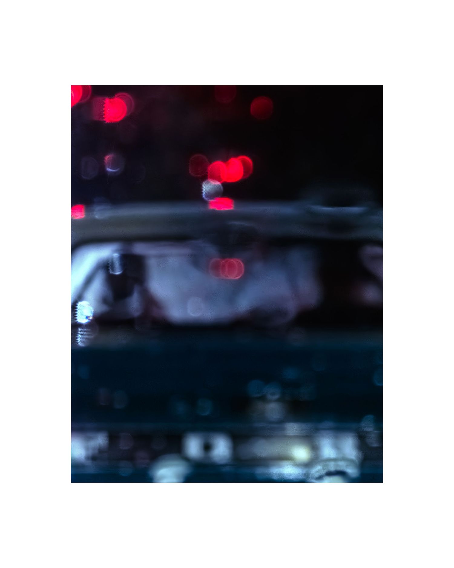 Abstract night photography with blurred red bokeh lights and dark reflections on a wet surface.