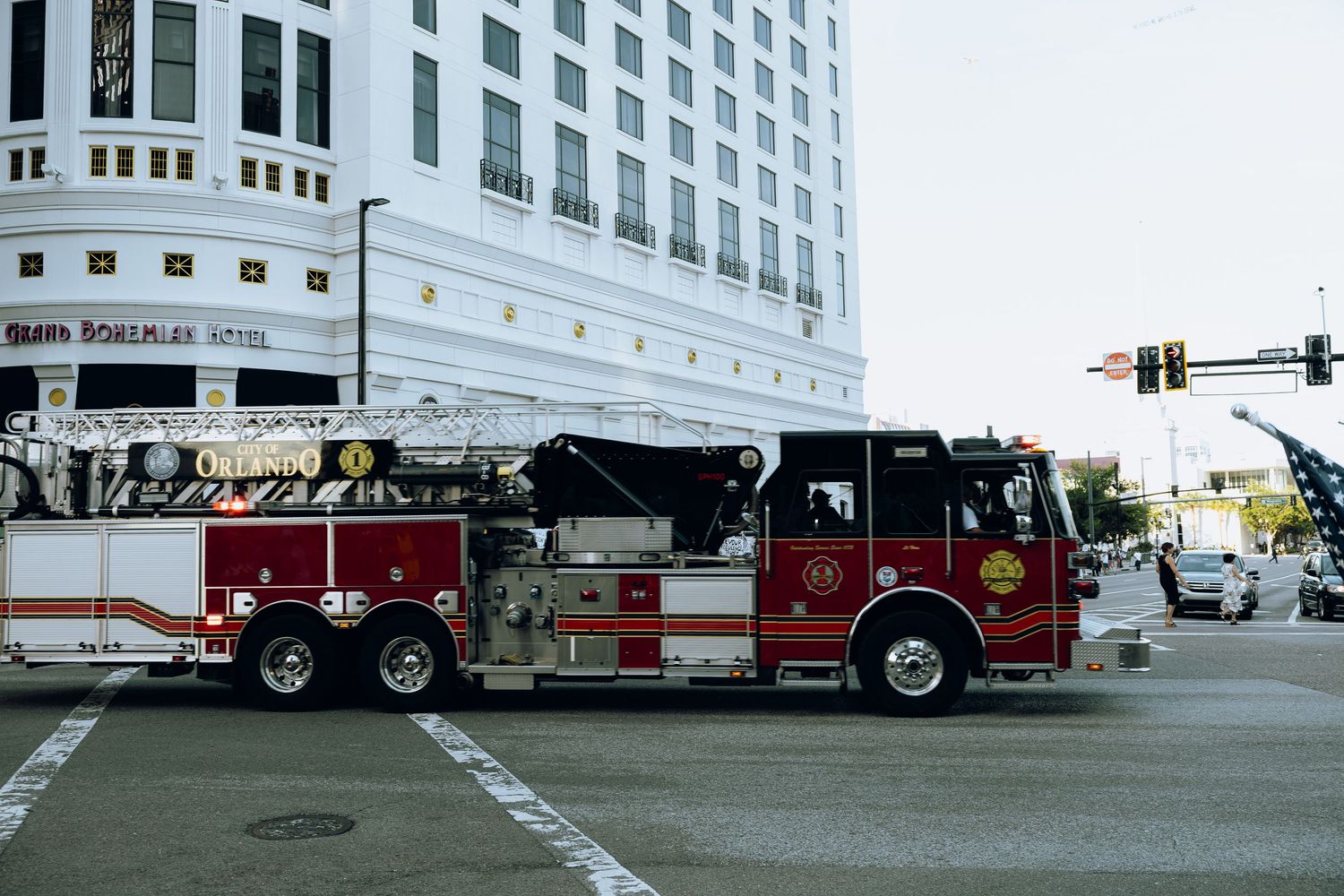 Fire truck parked outside modern white building in urban setting.
