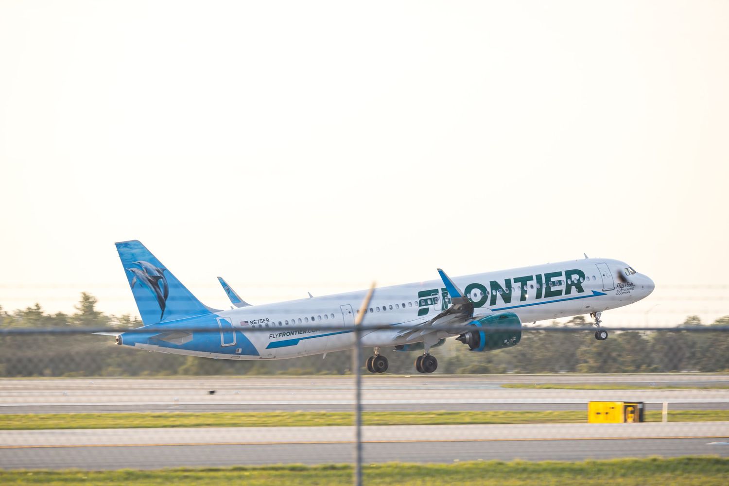 Frontier Airlines Airbus A321 aircraft taking off from runway, featuring blue and white livery with animal tail design.