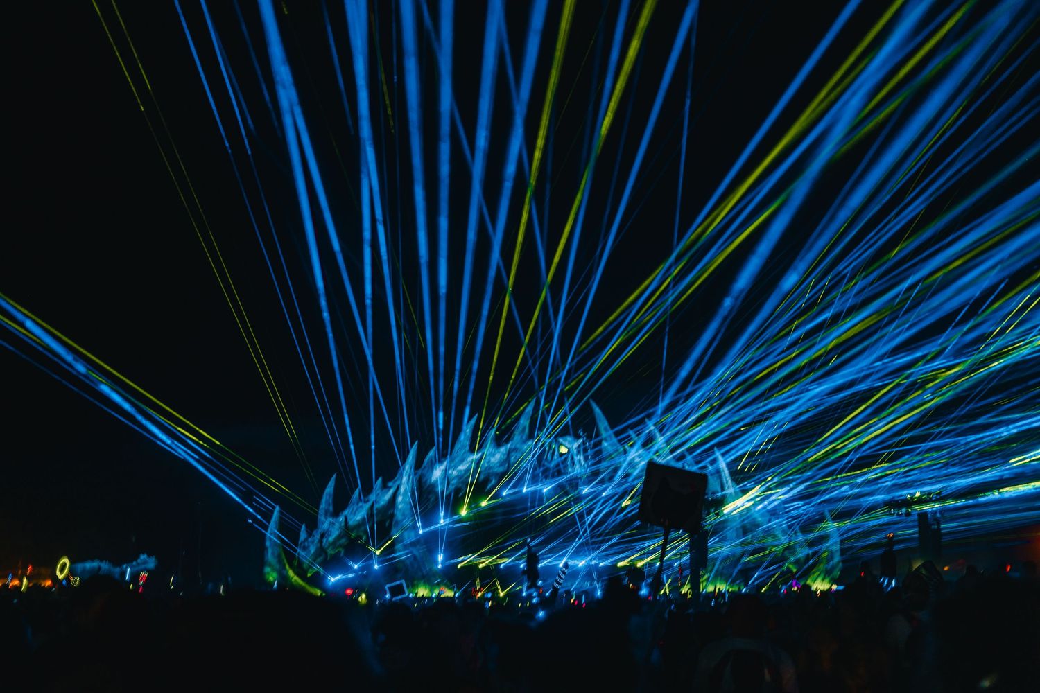 Blue laser beams illuminate the night sky in a stunning light show display creating dramatic patterns against darkness.