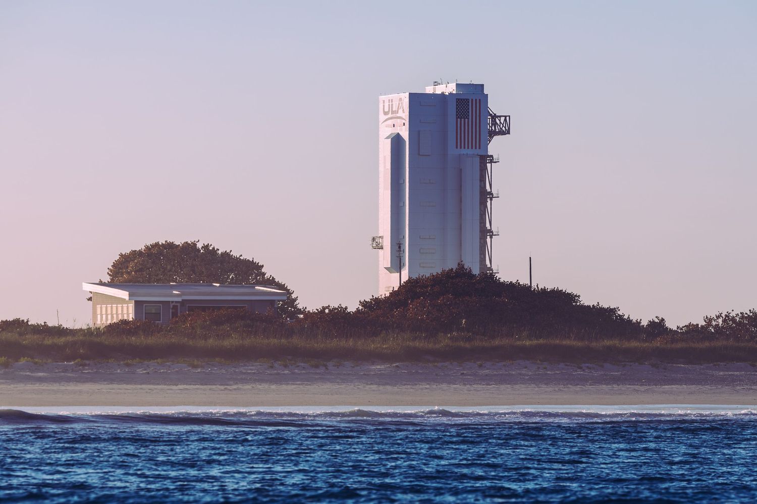 NASA Vehicle Assembly Building at Kennedy Space Center viewed across water at dusk, Cape Canaveral, Florida.