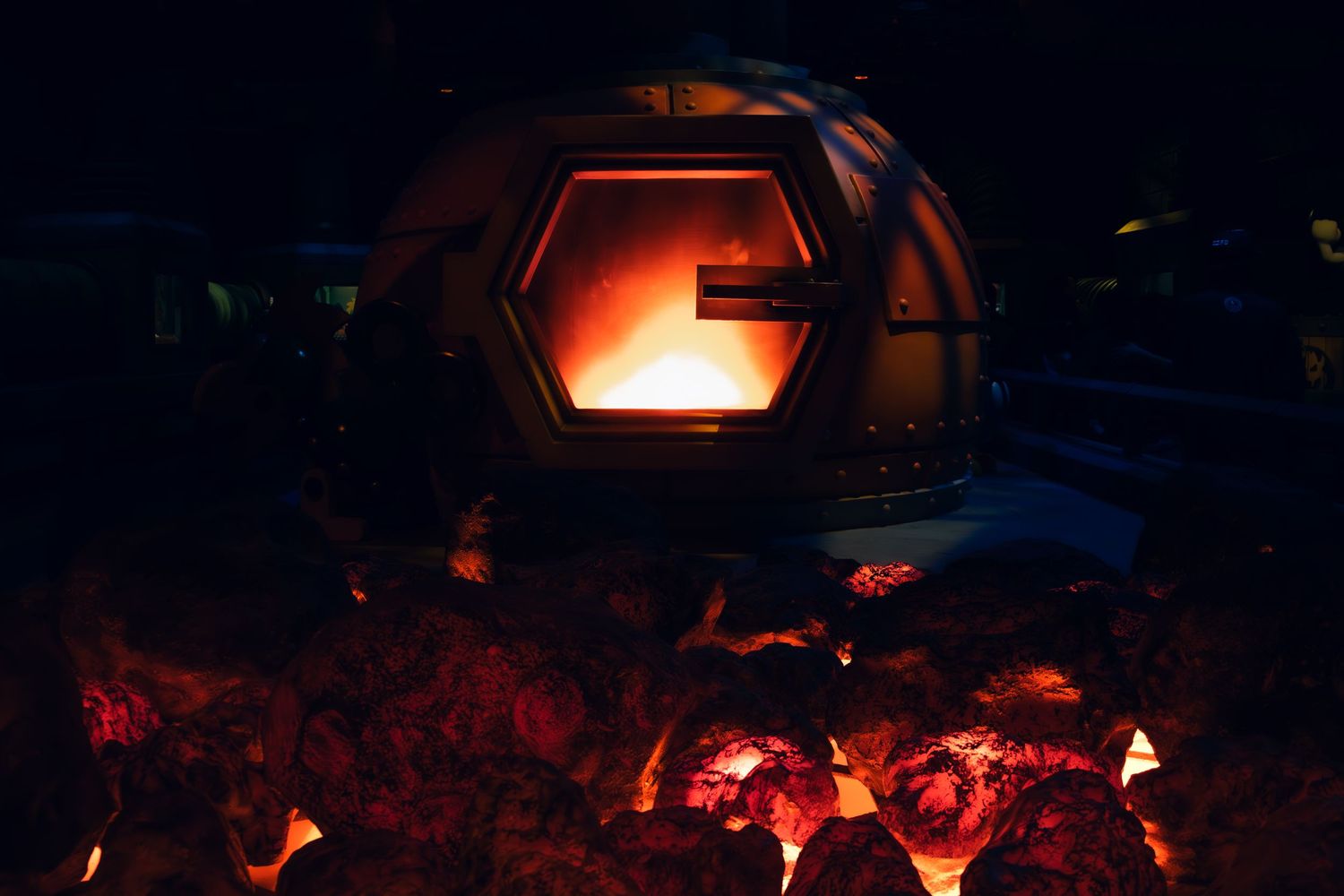 A glowing hexagonal fireplace radiates warmth over burning embers in the darkness.