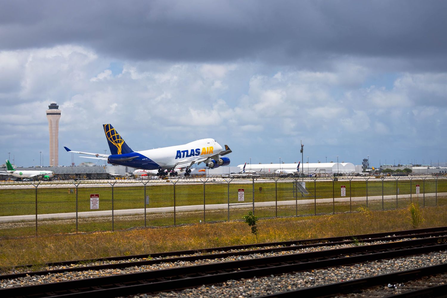 Atlas Air Boeing 747 cargo plane taking off from Miami International Airport under cloudy skies.