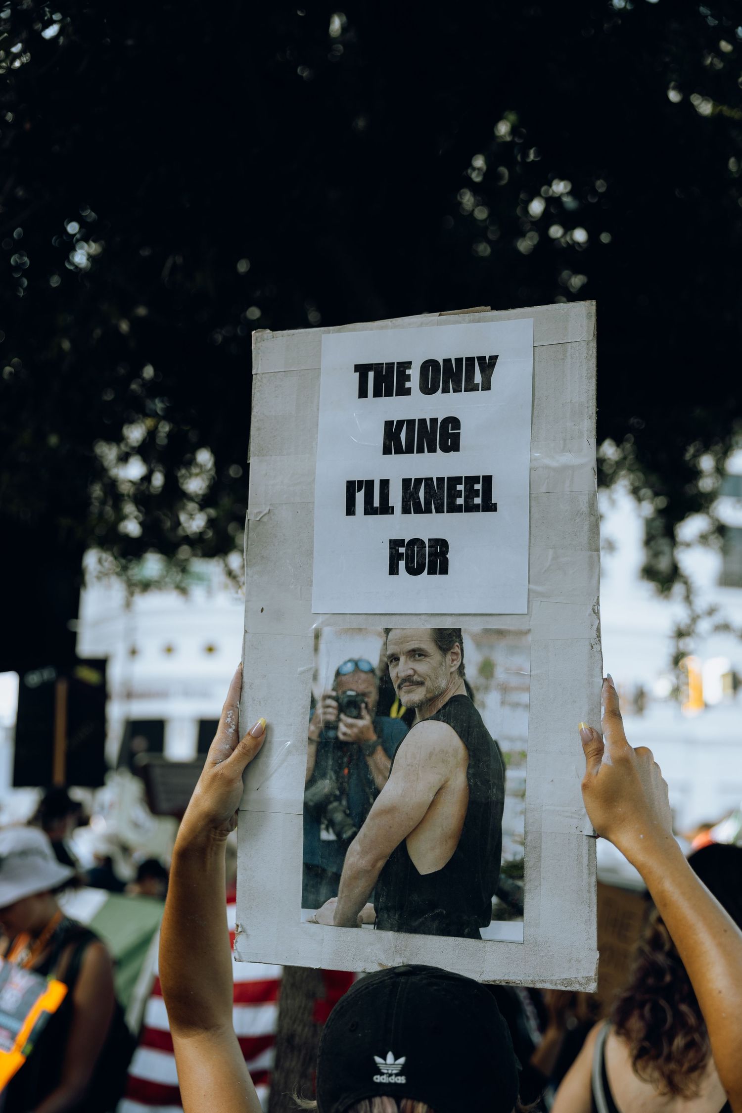 Protest sign stating 'The Only King I'll Kneel For' with a photo displayed at a demonstration.