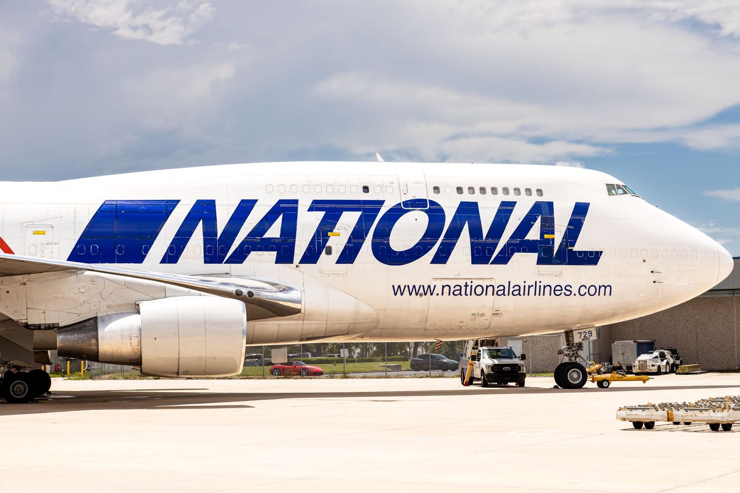 National Airlines Boeing 747 cargo aircraft parked on tarmac, featuring bold blue livery and website URL on fuselage.