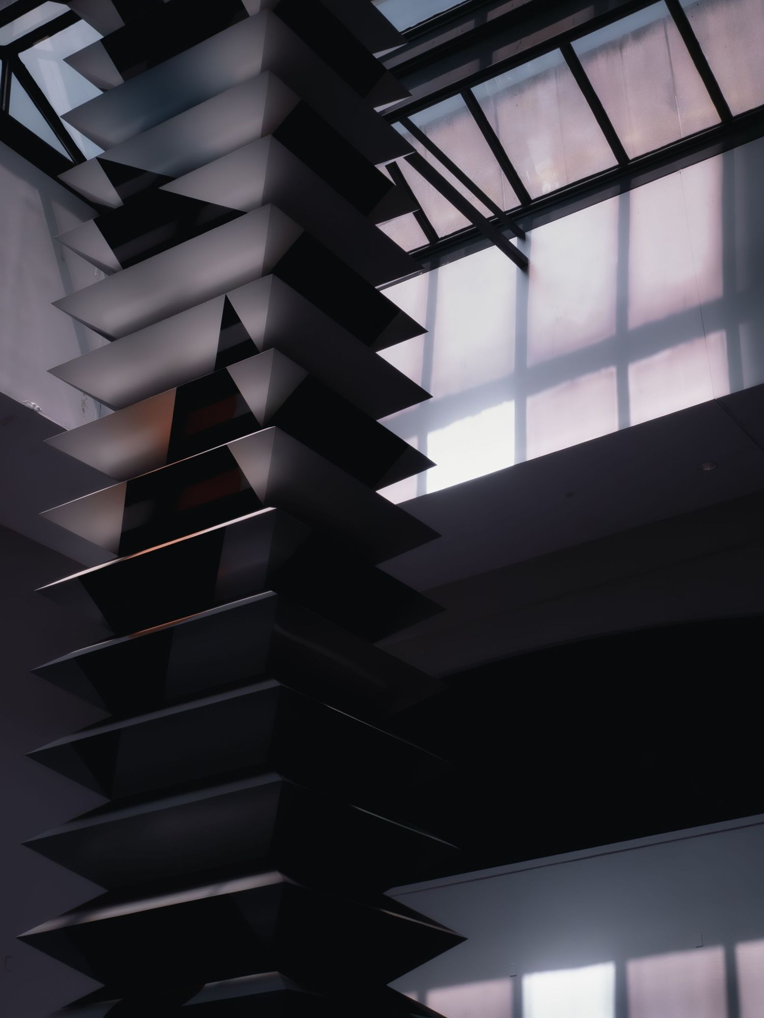 Geometric window blinds cast dramatic shadows and lines against natural light filtering through translucent windows.