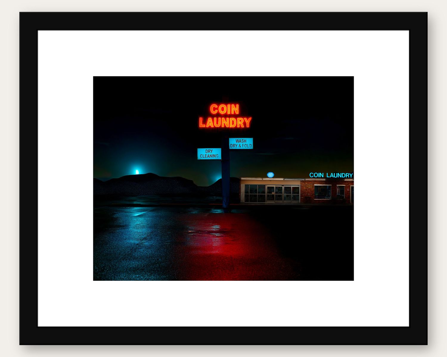 Neon coin laundry sign glowing red and blue against a dark night sky, reflected on wet pavement.