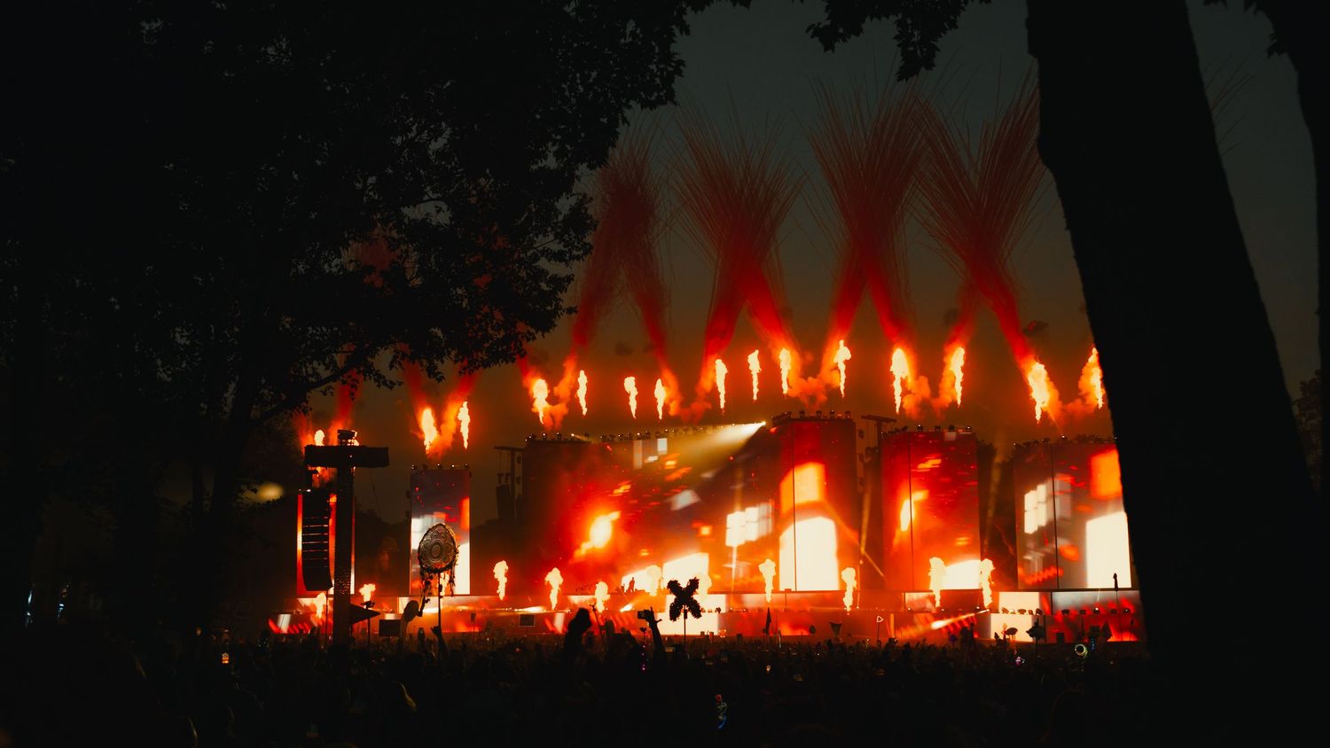 A row of glowing candles creates a warm, atmospheric display against a dark background in a church or sacred space.