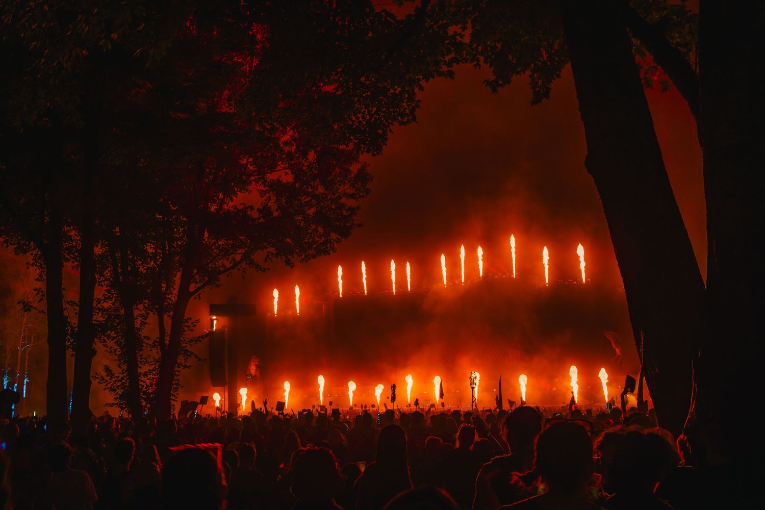 A row of glowing orange candles illuminates a dark outdoor setting creating an atmospheric nighttime scene.