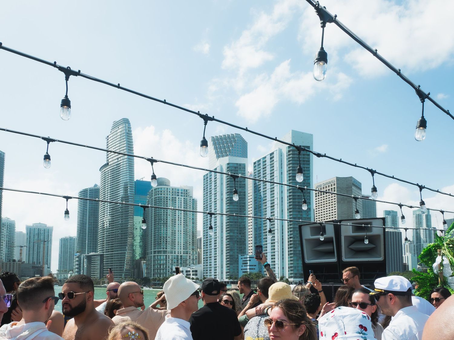 Outdoor rooftop party with string lights overlooking modern city skyline and glass skyscrapers in downtown Chicago.