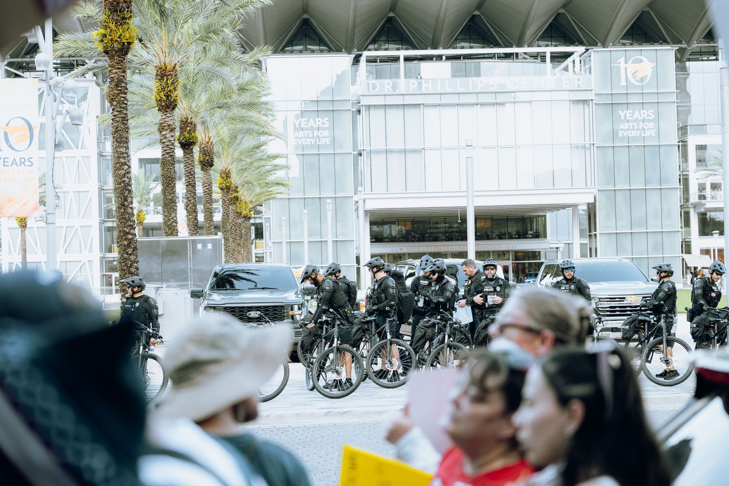 Line of police bicycles parked outside modern building during protest gathering.