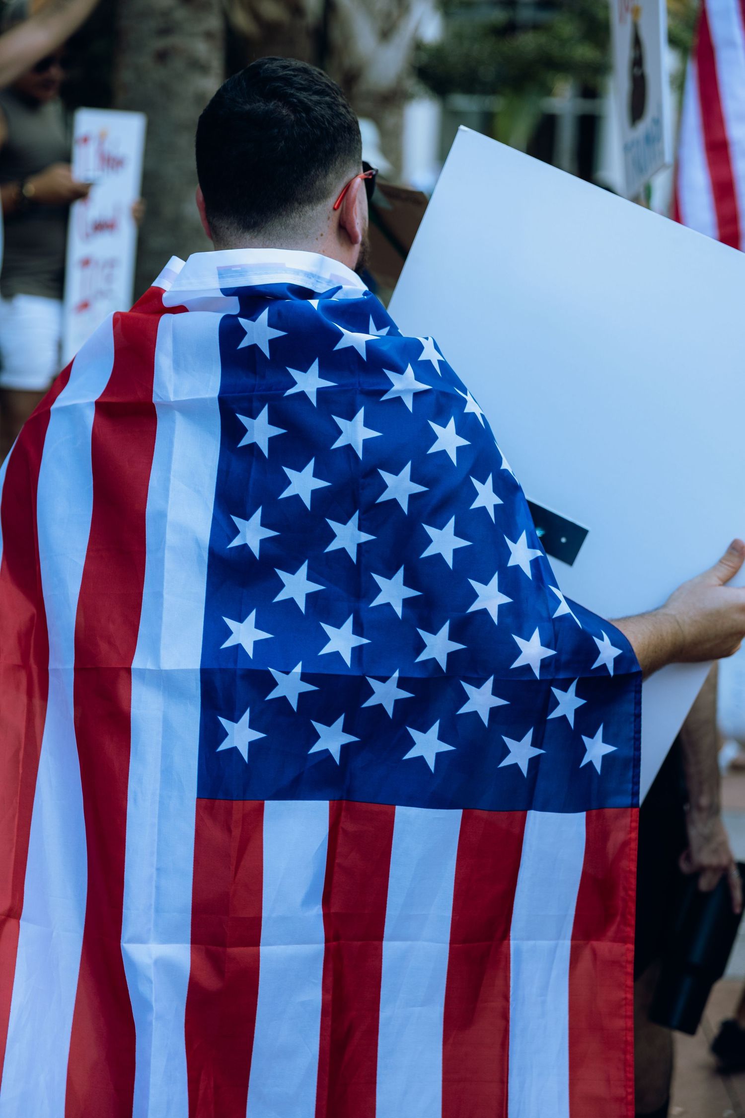 A row of American flags against a blurred background creates a patriotic backdrop display.