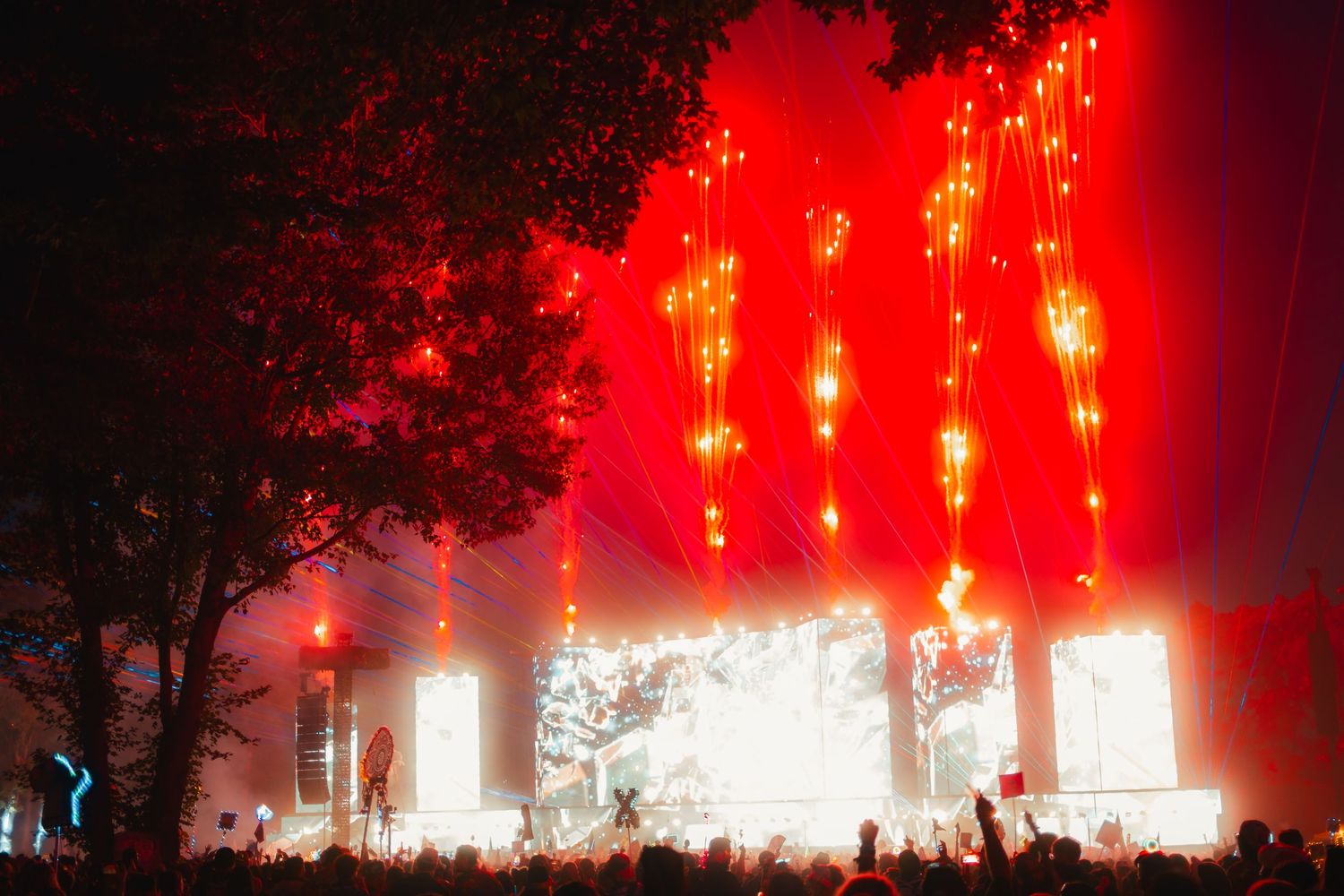 Concert stage illuminated with dramatic red lighting and smoke effects creates an atmospheric performance environment.
