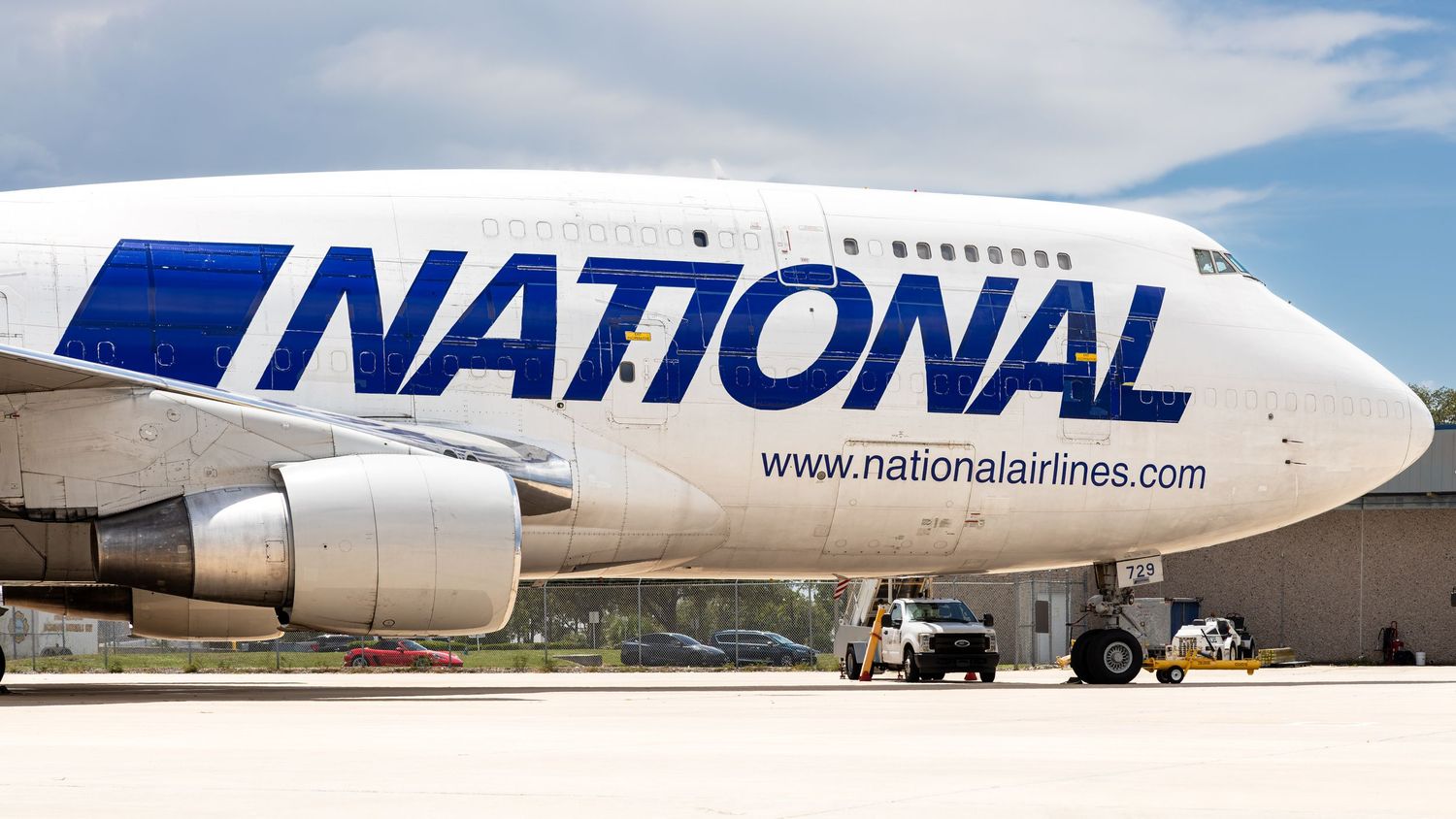 National Airlines Boeing 747 cargo aircraft on tarmac, featuring bold blue livery and nationalairlines.com website.