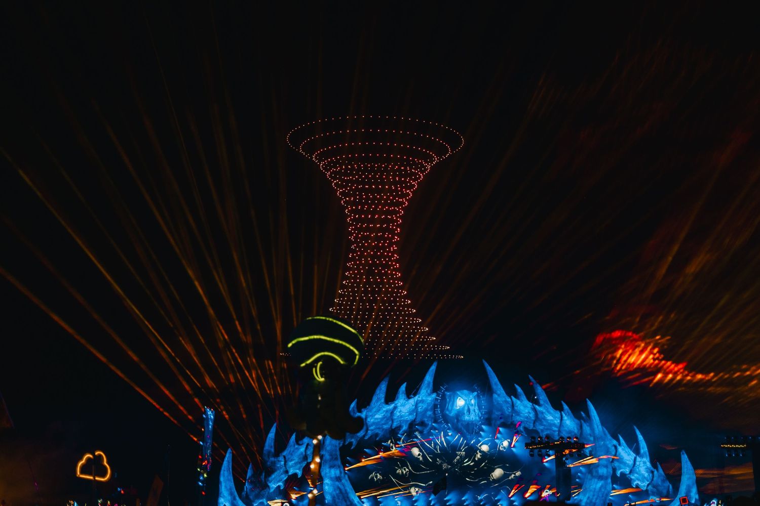 Colorful light show display with red and blue beams creating geometric patterns against a dark background.