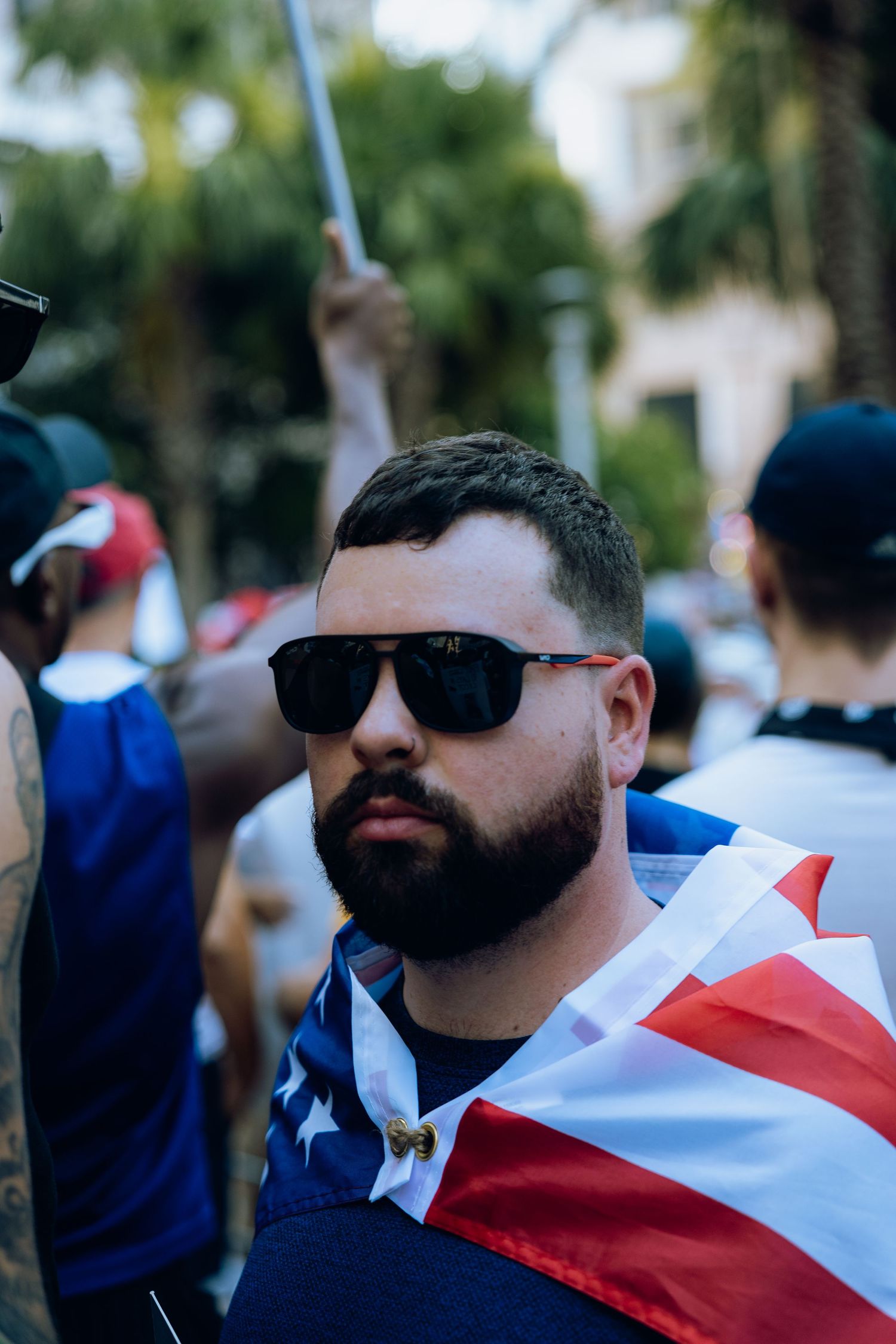 A person wearing sunglasses and American flag attire at an outdoor gathering.
