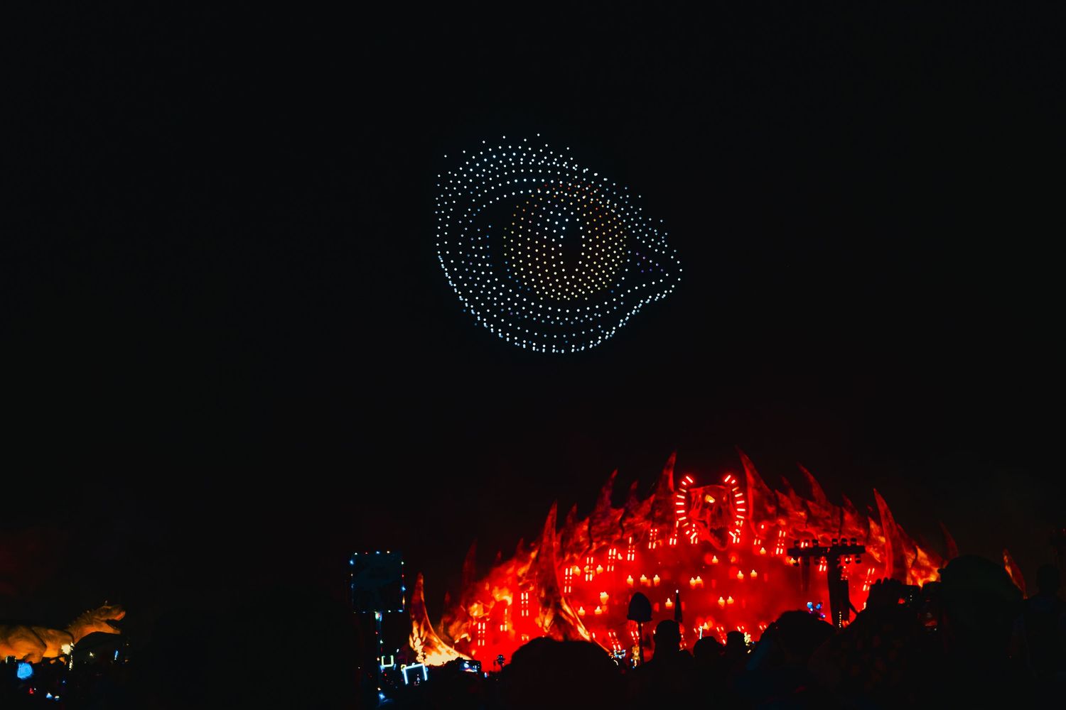A glowing orange eye design created with illuminated dots against a dark background.