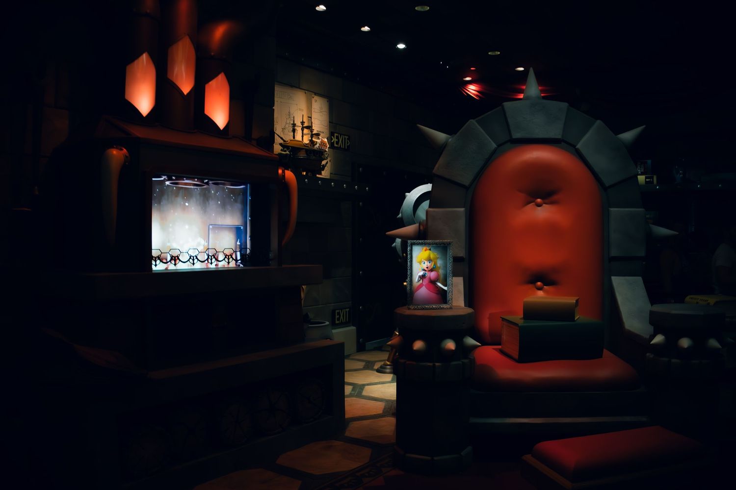 A dark themed entertainment venue with glowing orange lighting and multiple screens in a theater-like setting.