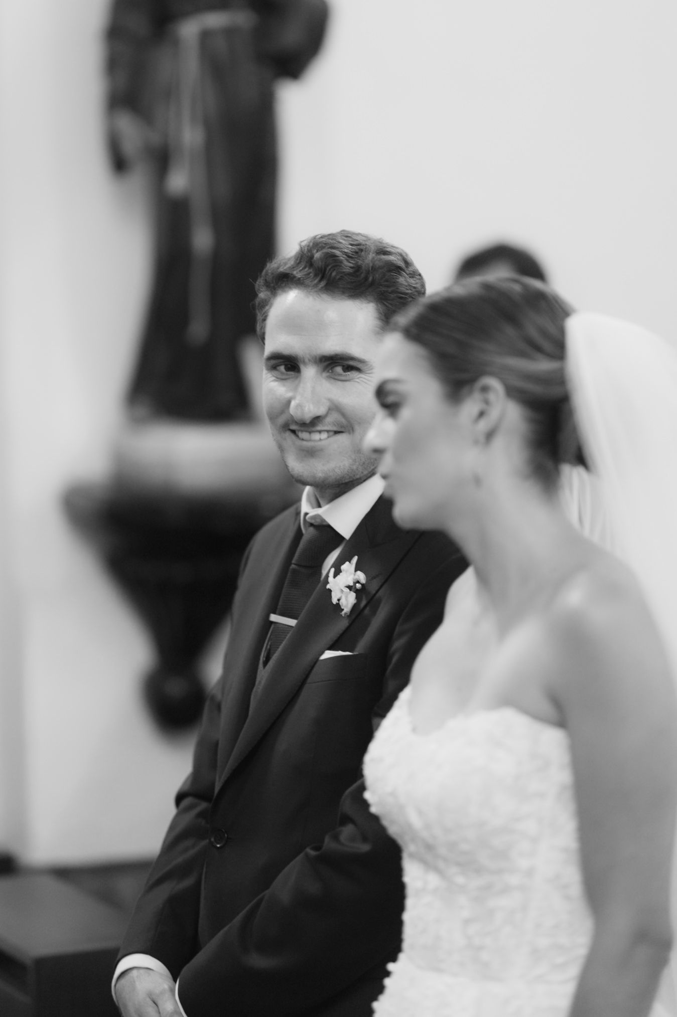 Tender moment captured during wedding ceremony as couple exchanges vows in church setting.