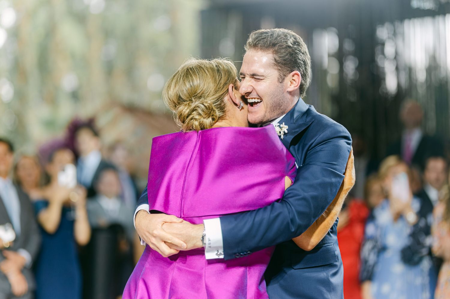 Two dancers share a joyful moment during a special dance at an evening wedding celebration.