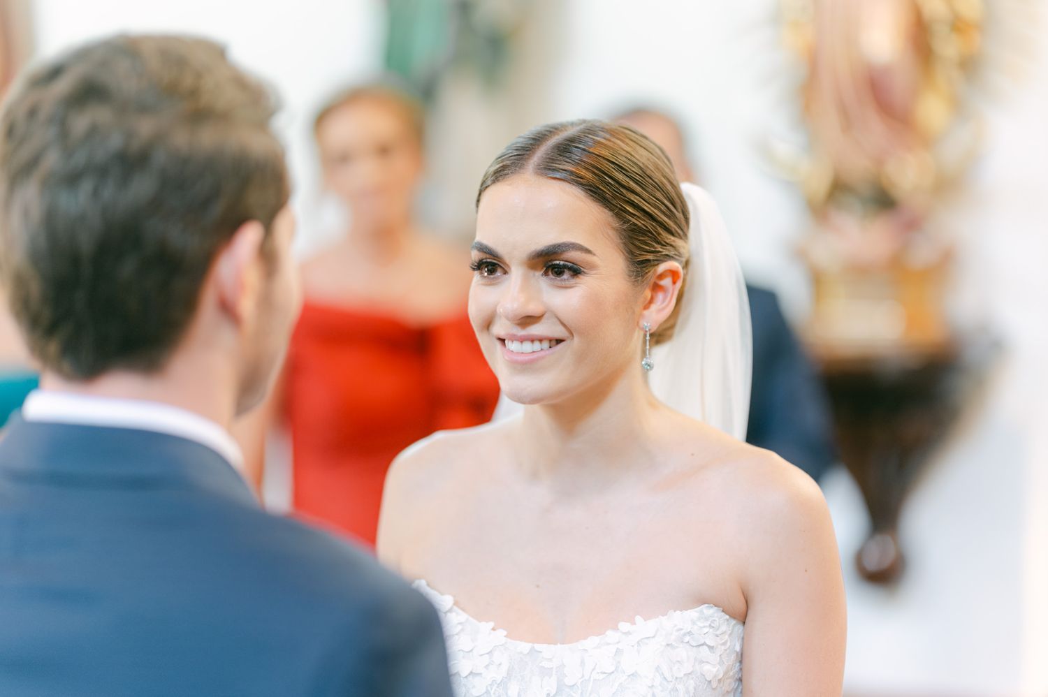 Elegant wedding ceremony moment captured in a light-filled chapel with decorative details.