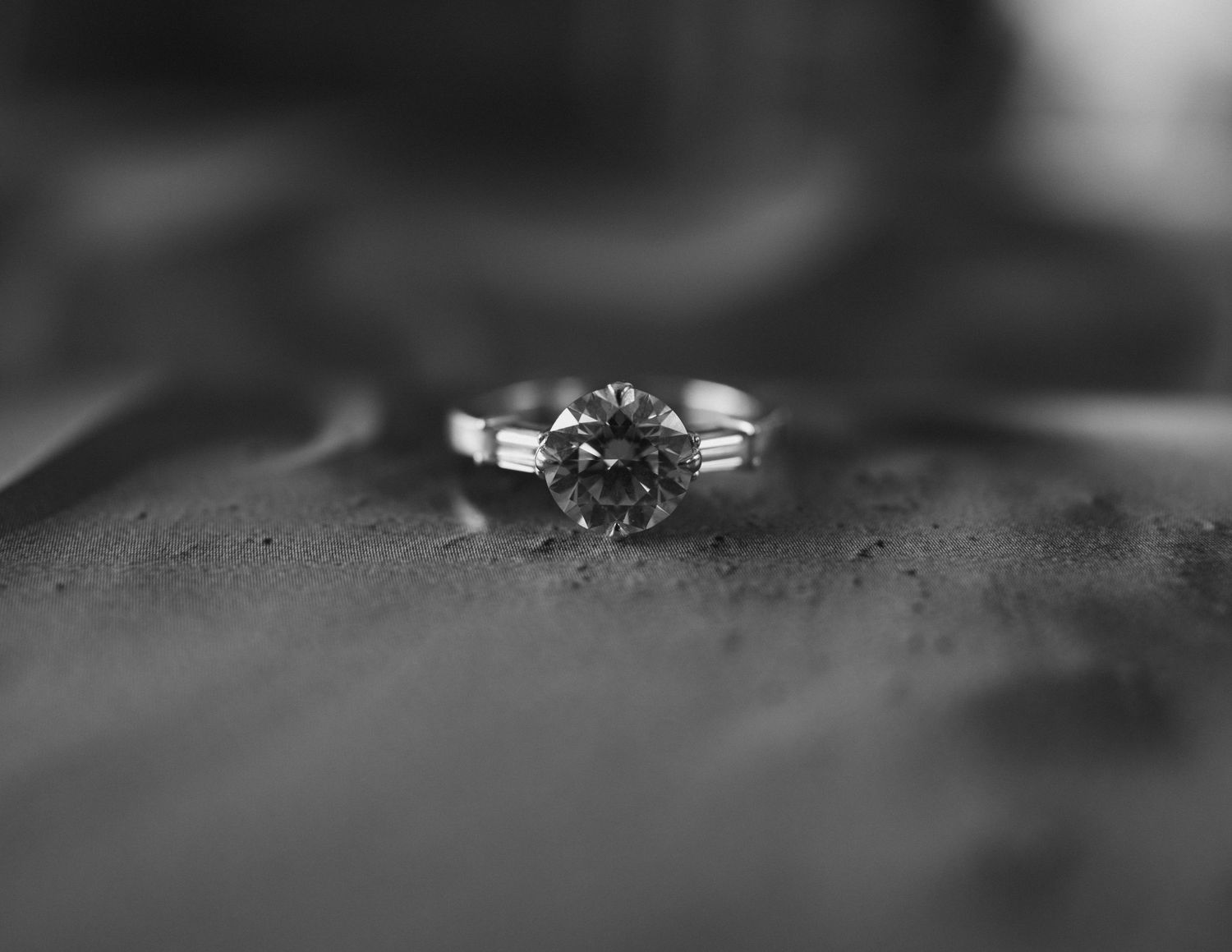 Close-up black and white photo of a stunning round diamond solitaire engagement ring.