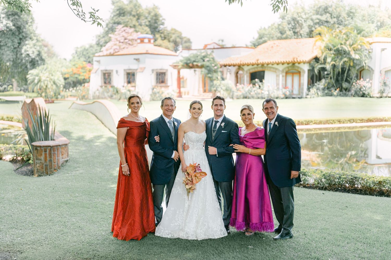 Outdoor wedding ceremony procession down floral-lined aisle with guests standing and colorful arrangements.